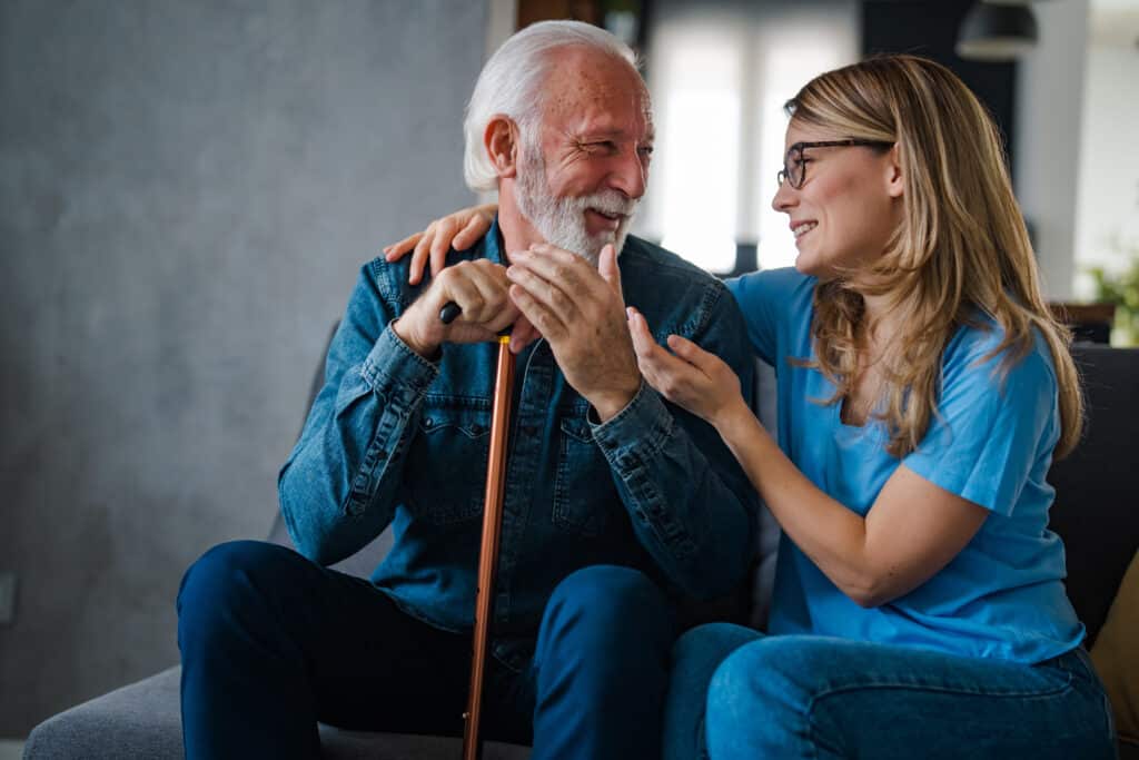 Smiling Elderly Man and Caregiver Sharing a Heartwarming Moment